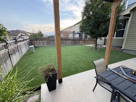 Clean artificial turf lawn beside a backyard patio