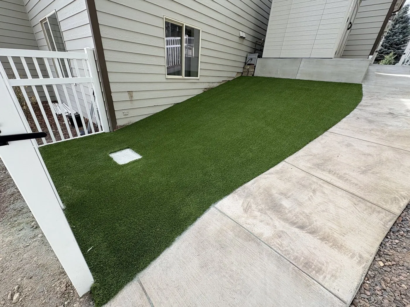 Narrow artificial turf side yard along a concrete edge