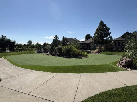 Backyard putting green and lawn seen from the driveway